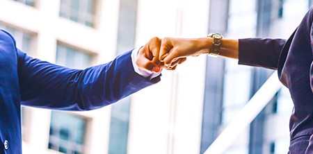 two business associates fist bump