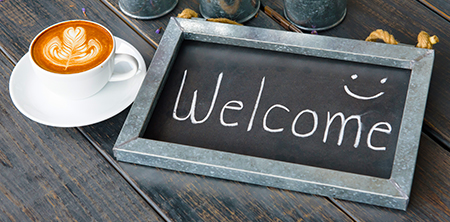 Welcome chalkboard with coffee cup and smiley face